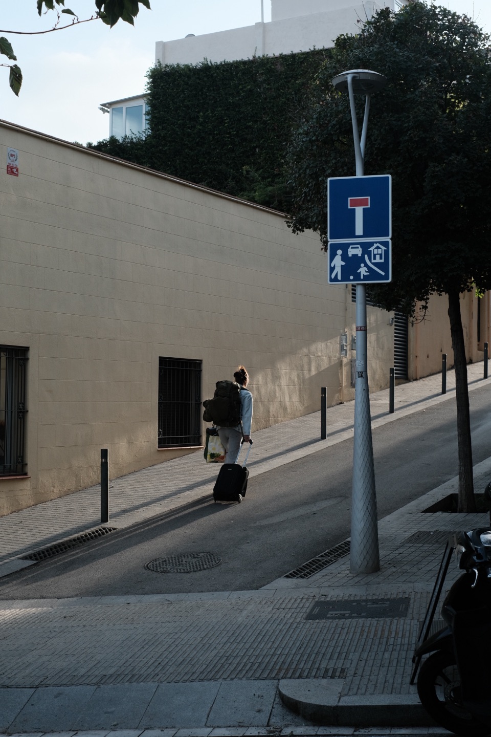 A street scene developed by an X-T4 with Classic Chrome; the shadows along the wall and under the tree are dark